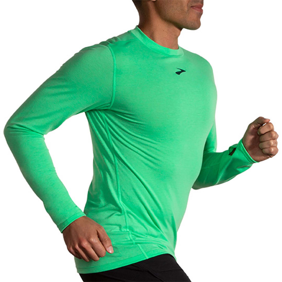Side view of a model wearing a Brooks Men's High Point Long Sleeve Top in the Hyper Green colourway. Model is also wearing Brooks legwear. (8177411260578)