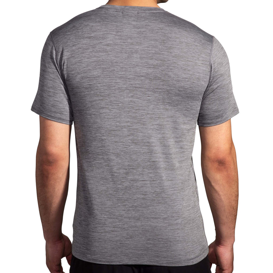 Back view of a model wearing a Brooks Men's Luxe Short Sleeve in the Heather Charcoal colourway. Model is also wearing Brooks legwear. (8177449074850)