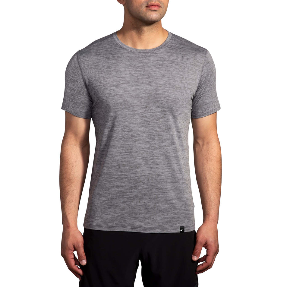 Front view of a model wearing a Brooks Men's Luxe Short Sleeve in the Heather Charcoal colourway. Model is also wearing Brooks legwear.  (8177449074850)