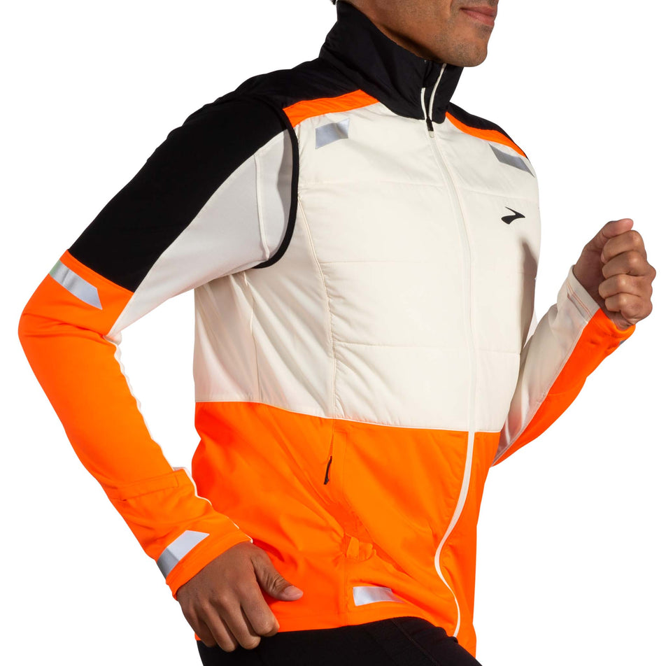 Angled view of a model wearing the Brooks Men's Run Visible Insulated Vest 2.0 in the Ecru/Fluoro Flash/Black colourway. (8778447224994)