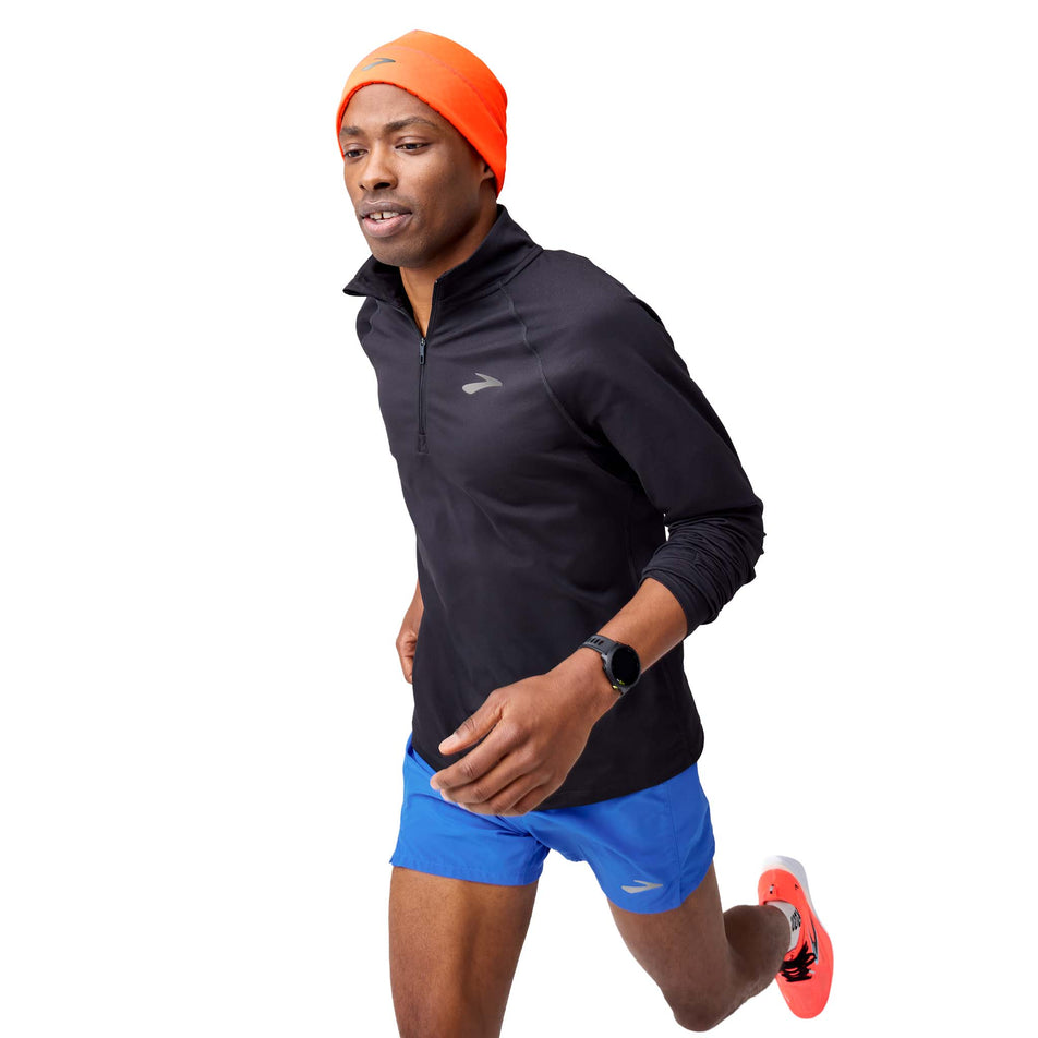 Angled view of a model wearing the Brooks Men's Dash 1/4 Zip 3.0 in the Black colourway.