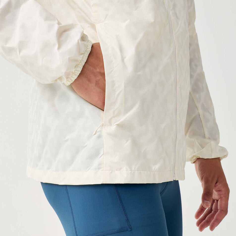 The side pocket on the Brooks Men's Canopy Reflective Jacket in the Reflective Wordmark Bone colourway.