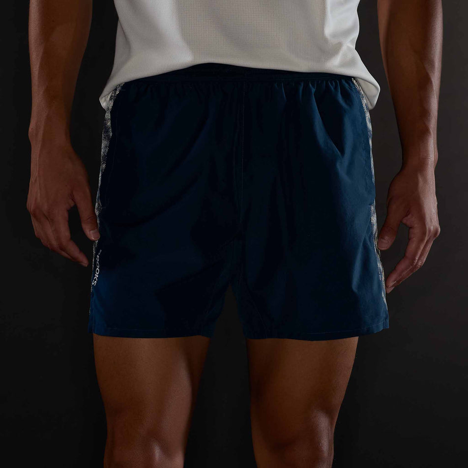 Front view of a model wearing the Brooks Men's Dash Reflective Short in the Reflective Wordmark Indigo colourway.