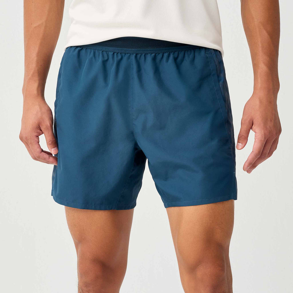 Front view of a model wearing the Brooks Men's Dash Reflective Short in the Reflective Wordmark Indigo colourway.