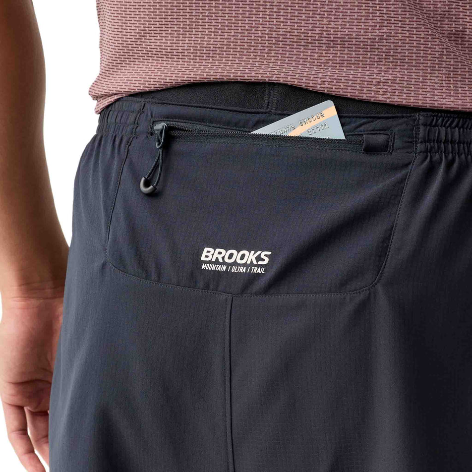 The zippered pocket on the back of the Brooks Men's Cascadia 2-In-1 Short in the Black colourway.