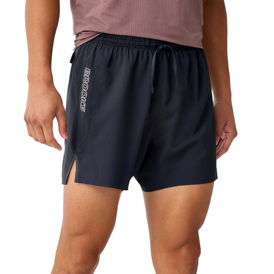 Front view a model wearing the Brooks Men's Cascadia 2-In-1 Short in the Black colourway.