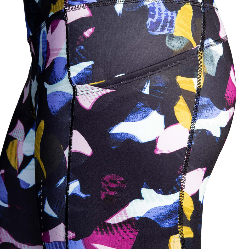 Close-up view of the stretch side pocket on the left thigh of a pair of Brooks Women's 7/8 Tights in the Fast Floral Print colourway (8007499481250)