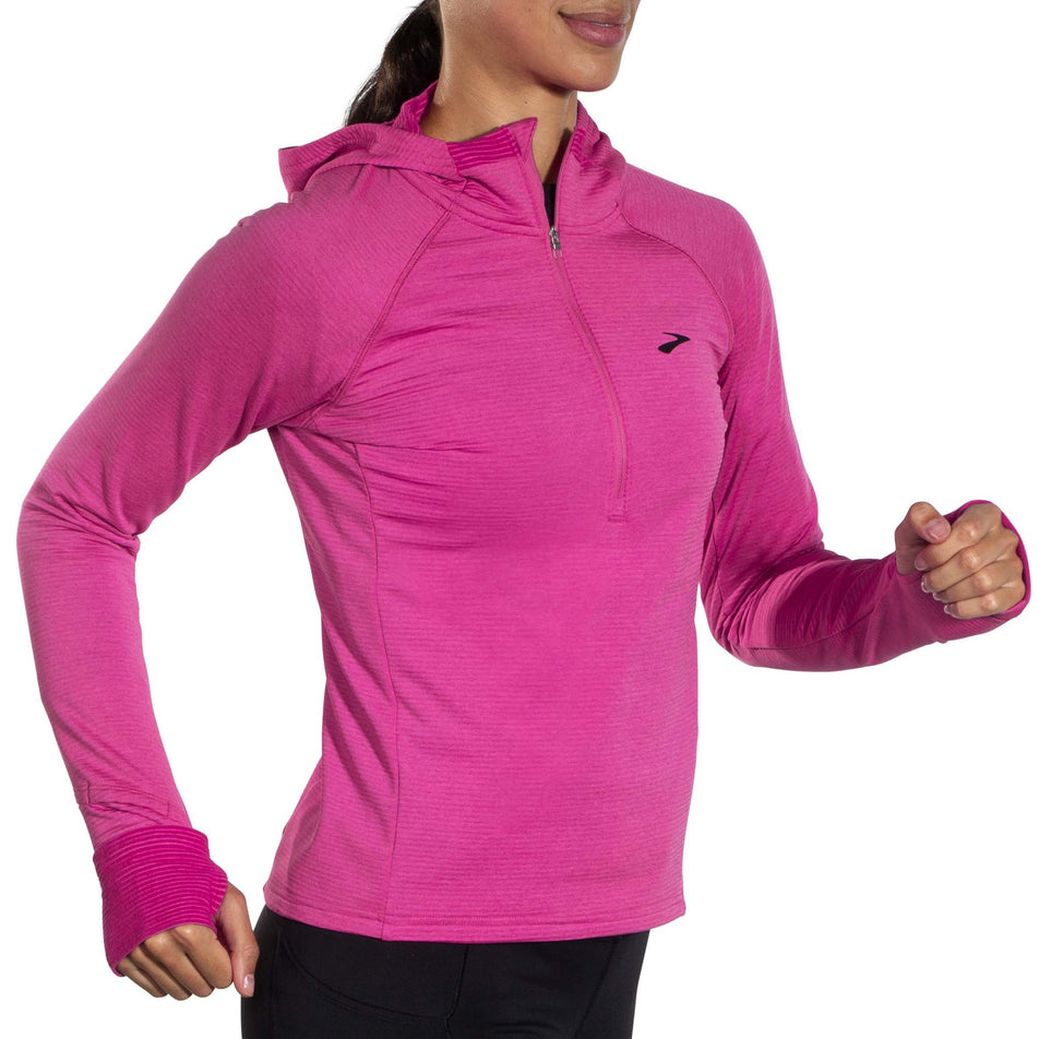 Angled front view of a model wearing a Brooks Women's Notch Thermal Hoodie 2.0 in the Heather Frosted Mauve colourway. Model is in a running pose.  (8007496007842)