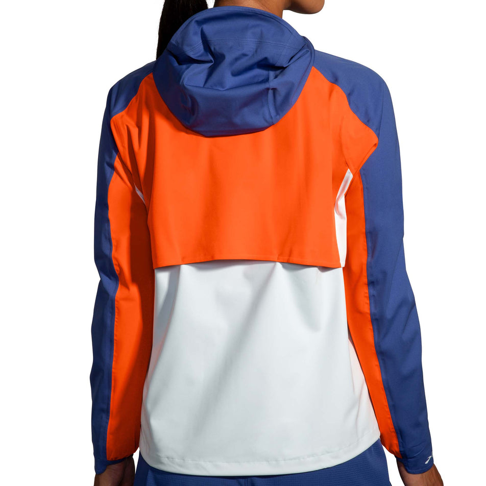Back view of a model wearing a Brooks Women's High Point Waterproof Jacket in the Lt Slate/Bright Orange/Aegean colourway (8037744771234)