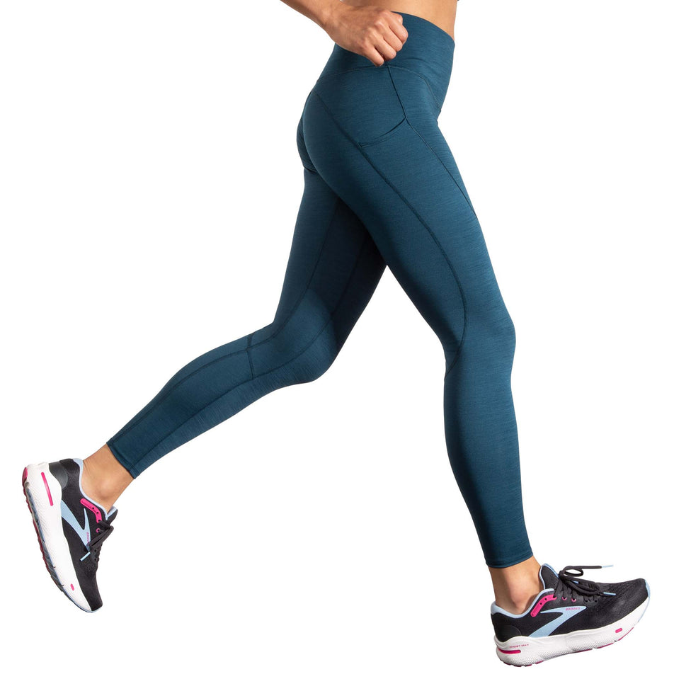 Side view of a model wearing the Women's Spark Tight in the Heather Ocean Drive colourway. Model is also wearing Brooks running shoes. (8177464017058)