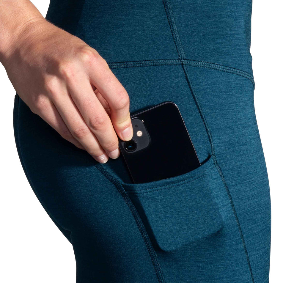 A model demonstrating the stretch pocket on the left thigh of the Women's Spark Tight. (8177464017058)