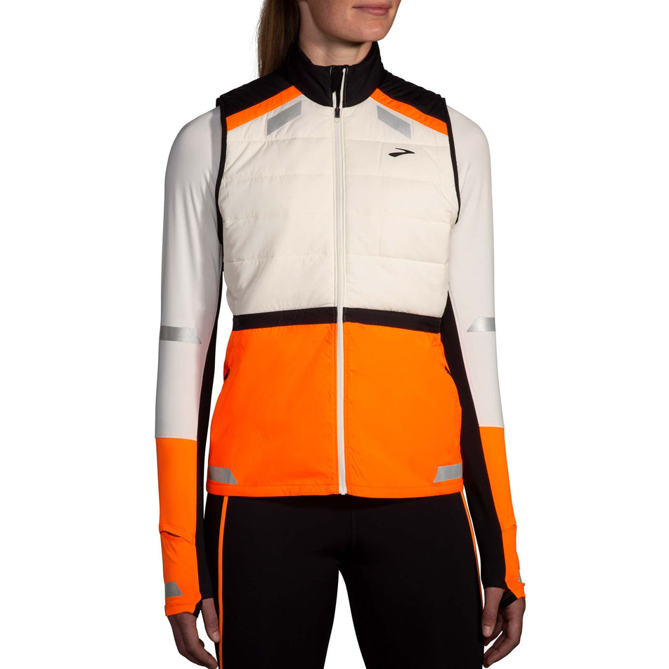 Front view of a model wearing the Brooks Women's Run Visible Insulated Vest 2.0 in the Ecru/Fluoro Flash/Black colourway. (8778453483682)