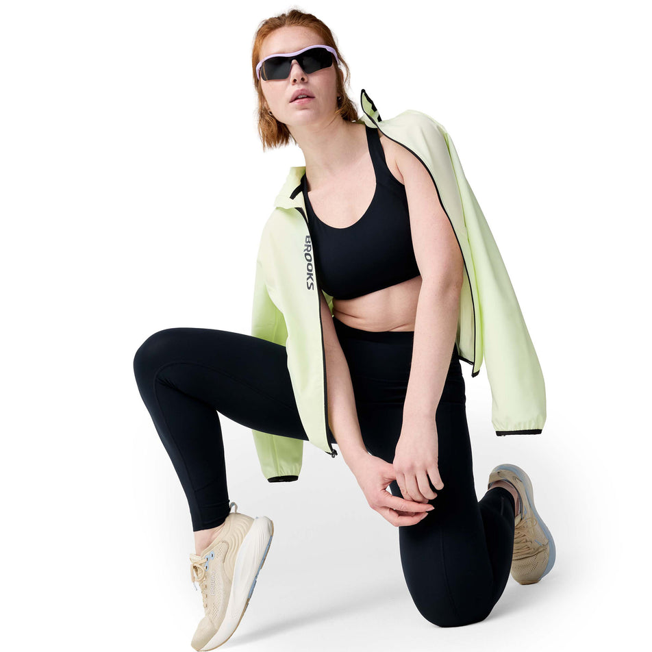 Angled view of a model wearing the Brooks Women's Chaser 7/8 Tight in the Black colourway.