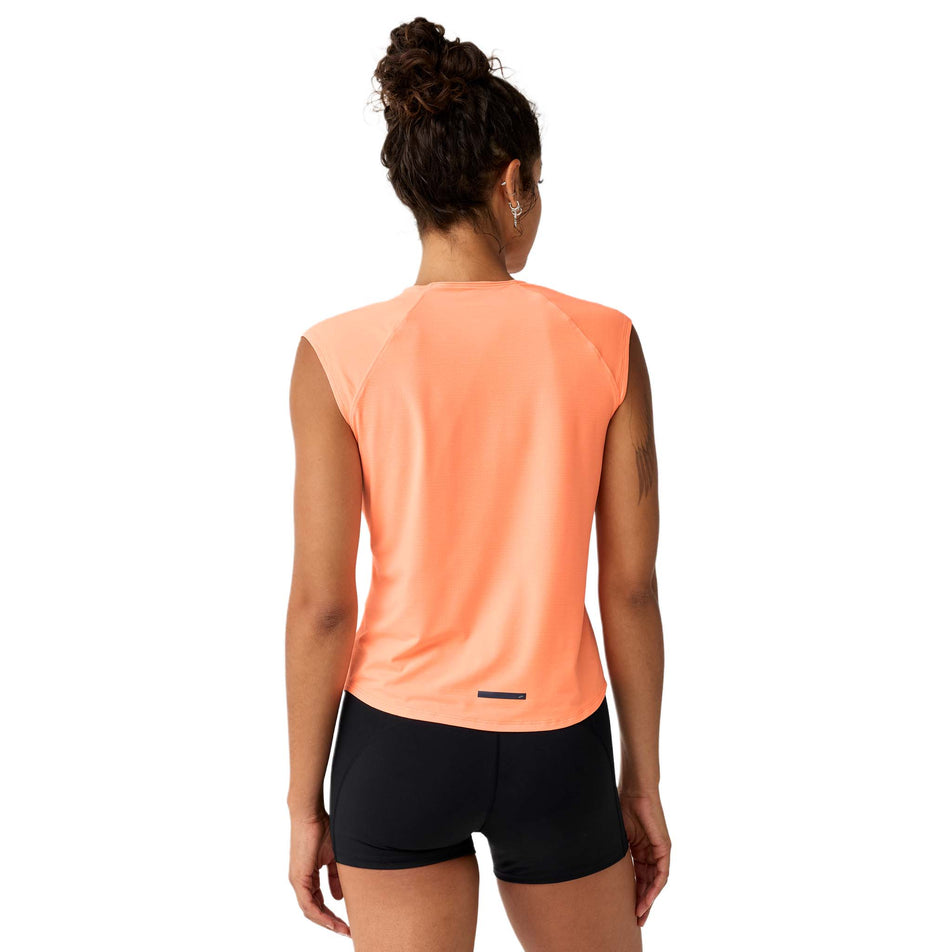Back view of a model wearing the Brooks Women's Dash Cooling Short Sleeve in the Cyber Peach colourway.