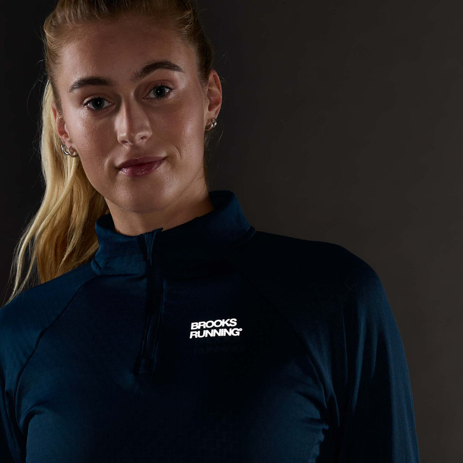 The reflective graphic on the front of the Brooks Women's Thermal Reflective 1/2 Zip in the Indigo/Reflective colourway.
