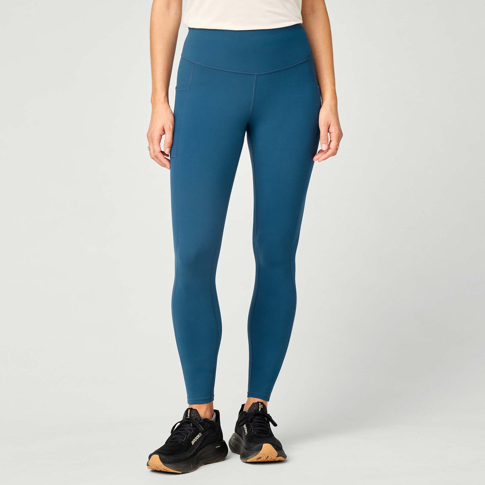 Front view of a model wearing the Brooks Women's Thermal Reflective Tight in the Indigo/Reflective colourway.