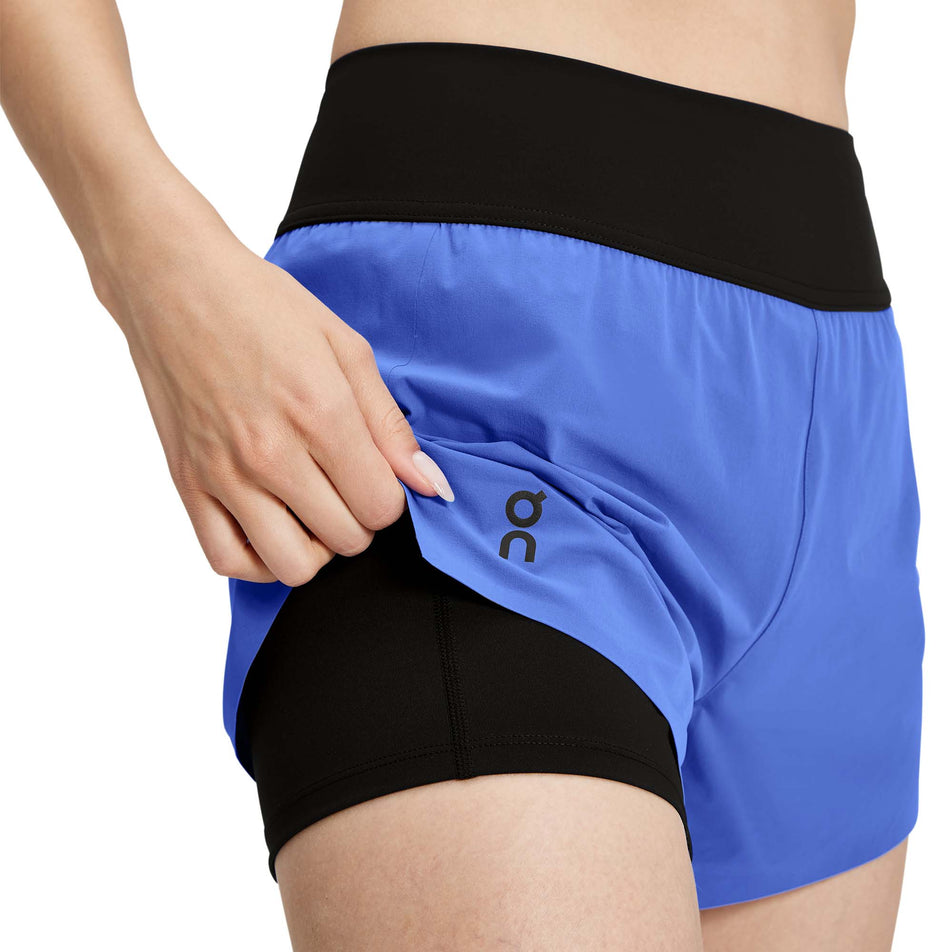 Front view of a model wearing a pair of On Women's Running Shorts in the Cobalt/Black colourway/Black colourway. (7926184444066)