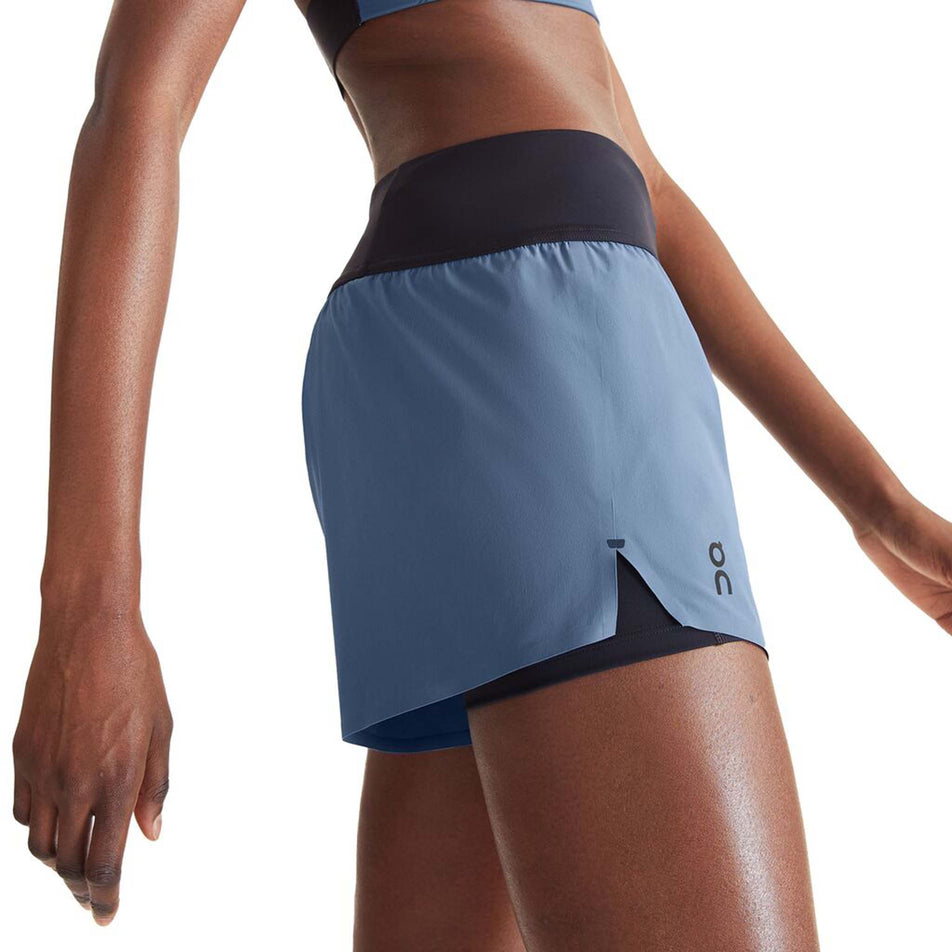 Close-up side view of a model wearing a pair of On Women's Running Shorts in the Stellar/Black colourway (8002757591202)