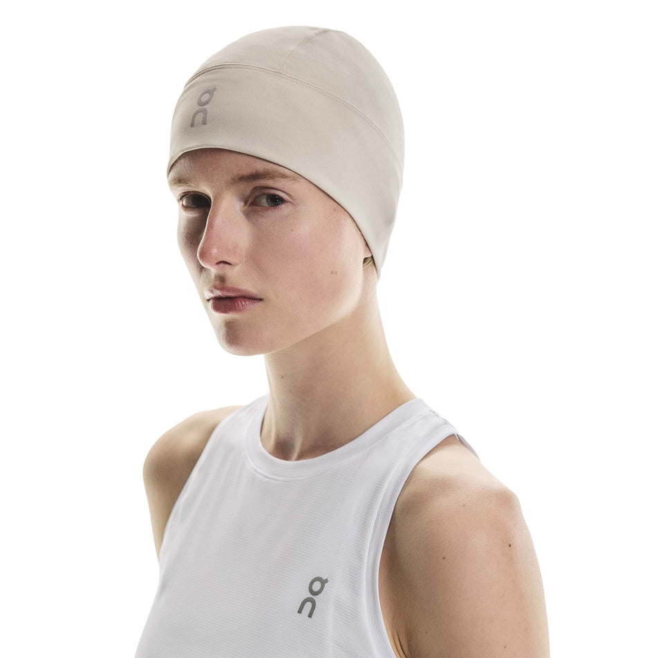 Front view of a model wearing the On Core Beanie in the Truffle colourway. (8717368000674)