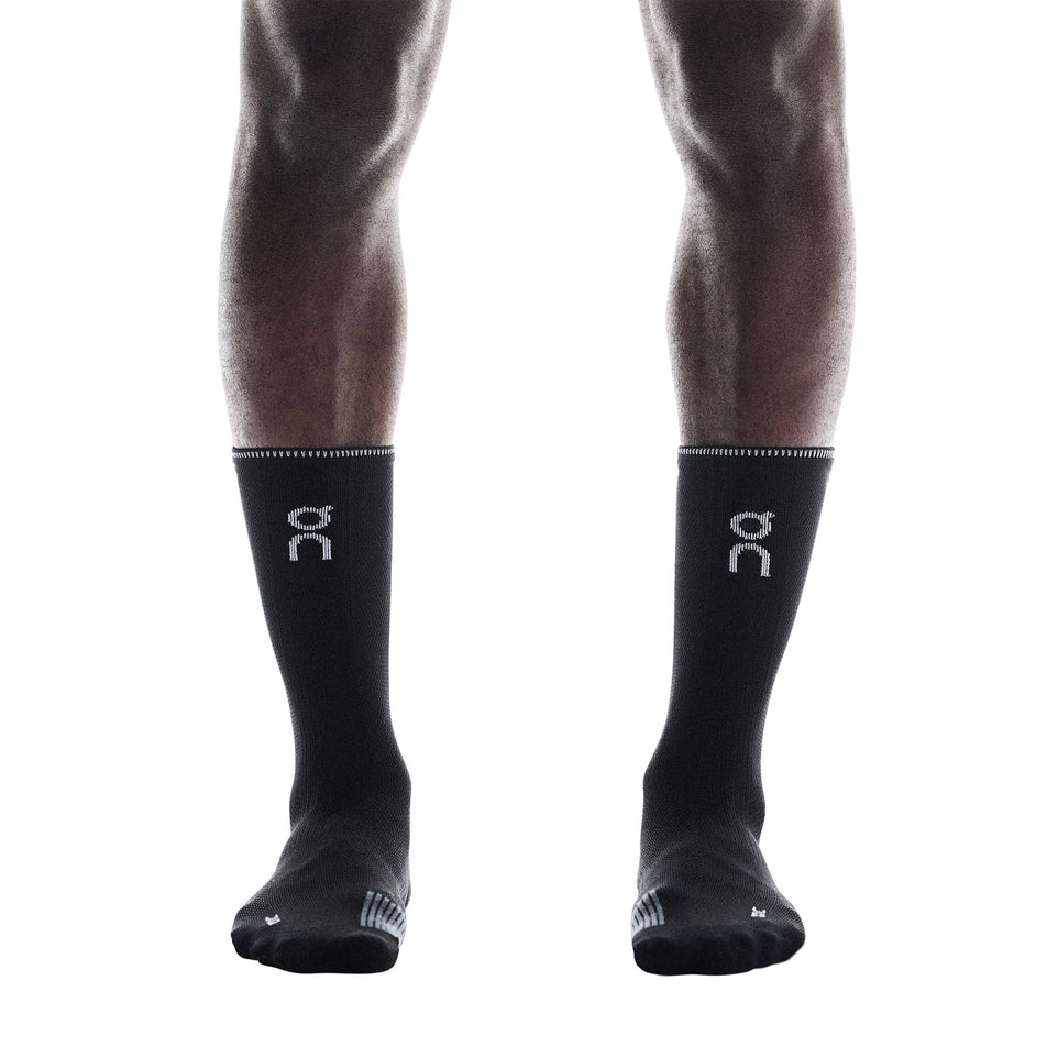 Front view of a model wearing a pair of On Unisex Performance Run Sock High in the Black/Eclipse colourway.