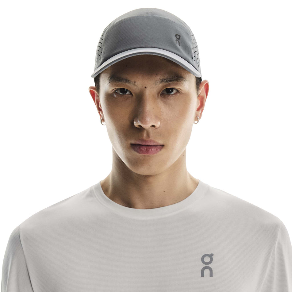 Front view of a model wearing the On Unisex Lightweight Cap in the Rock colourway. (8717297385634)