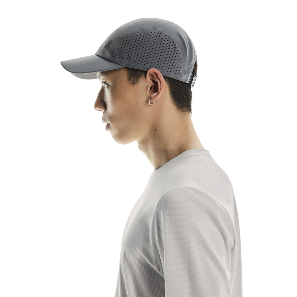 Side view of a model wearing the On Unisex Lightweight Cap in the Rock colourway. (8717297385634)