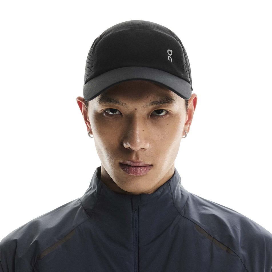 Front view of a model wearing the On Unisex Lightweight Cap in the Black colourway.