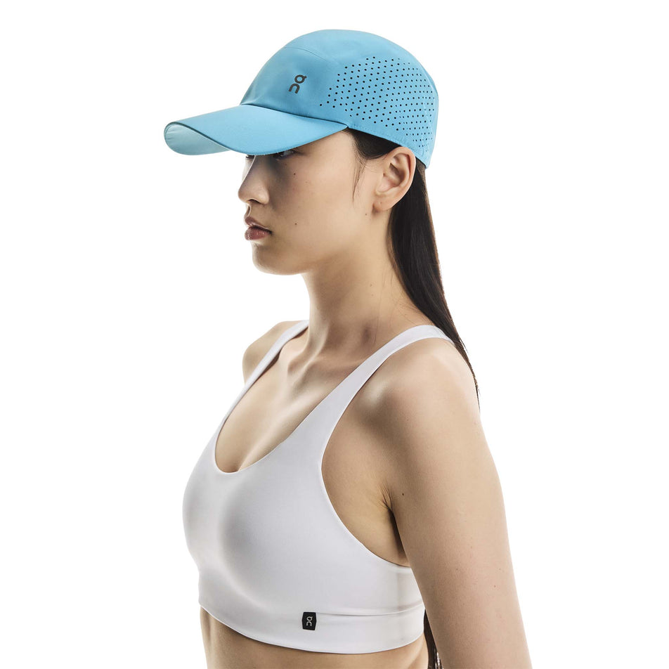 Angled view of a model wearing the On Unisex Lightweight Cap in the Niagara colourway. (8717299908770)