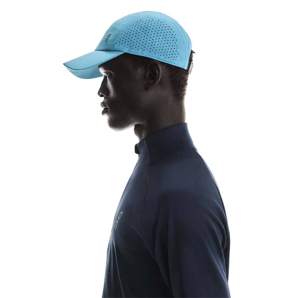 Side view of a model wearing the On Unisex Lightweight Cap in the Niagara colourway. (8717299908770)
