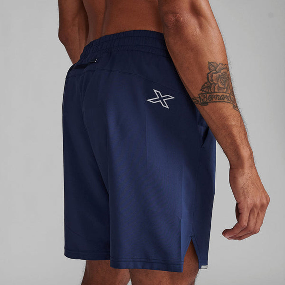 Angled back view of a model wearing a pair of 2XU Men's Aero 7 Inch Shorts in the Midnight/Silver Reflective colourway (8248602427554)