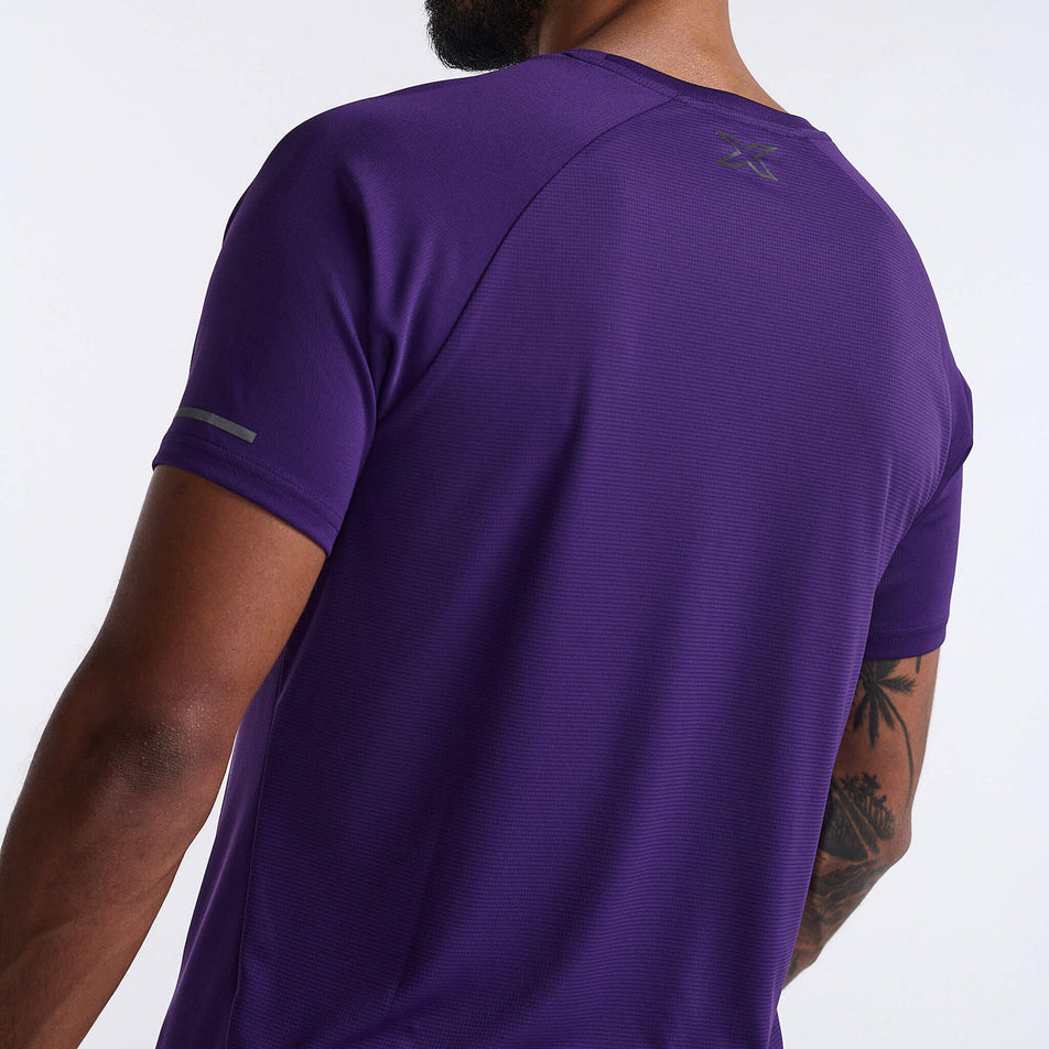 Close-up angled back view of a model wearing a 2XU Men's Aero Tee in the Acai/Black Reflective colourway. (8248600920226)