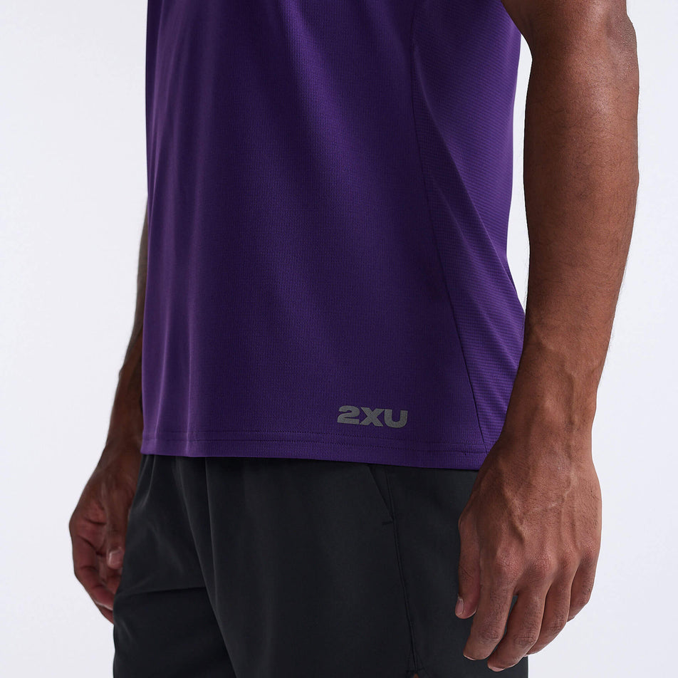 Close-up angled front view of a model wearing a 2XU Men's Aero Tank in the Acai/Black Reflective colourway. The lower section of the 2XU tank can been seen in the image (8248599052450)