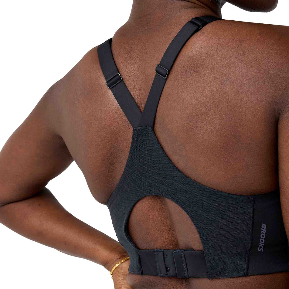 Back view of a model wearing the Brooks Women's Limitless Racer Bra in the Black colourway.