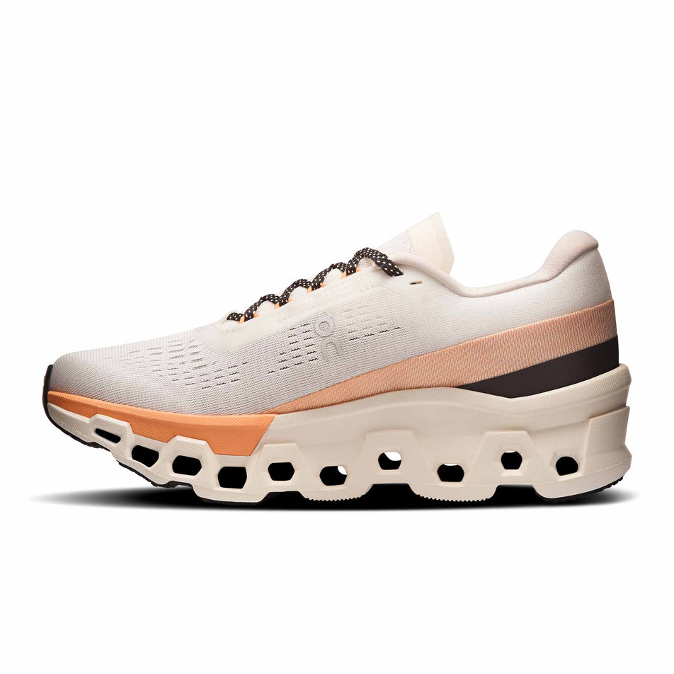 Medial view of the right shoe from a pair of On Women's Cloudmonster 2 Running Shoes in the Ivory/Tangerine colourway. (8714534453410)