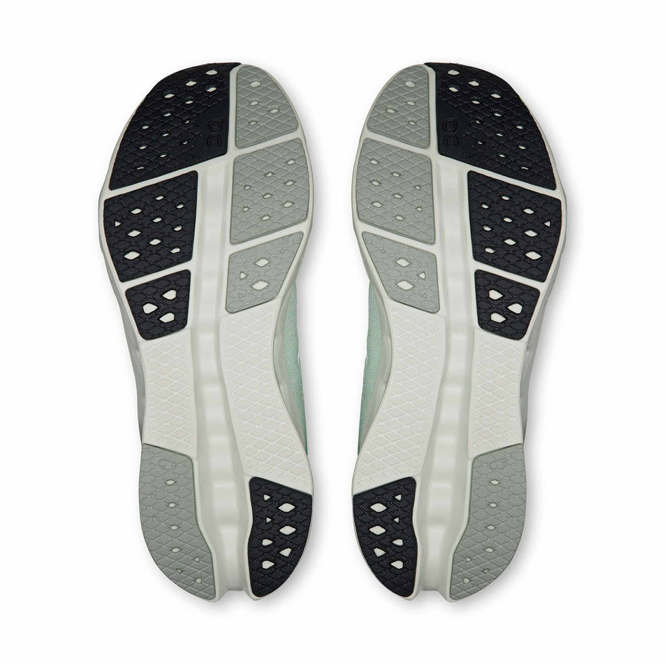 The outsoles of a pair of On Women's Cloudsurfer 2 Running Shoes in the Ivory/Creek colourway.