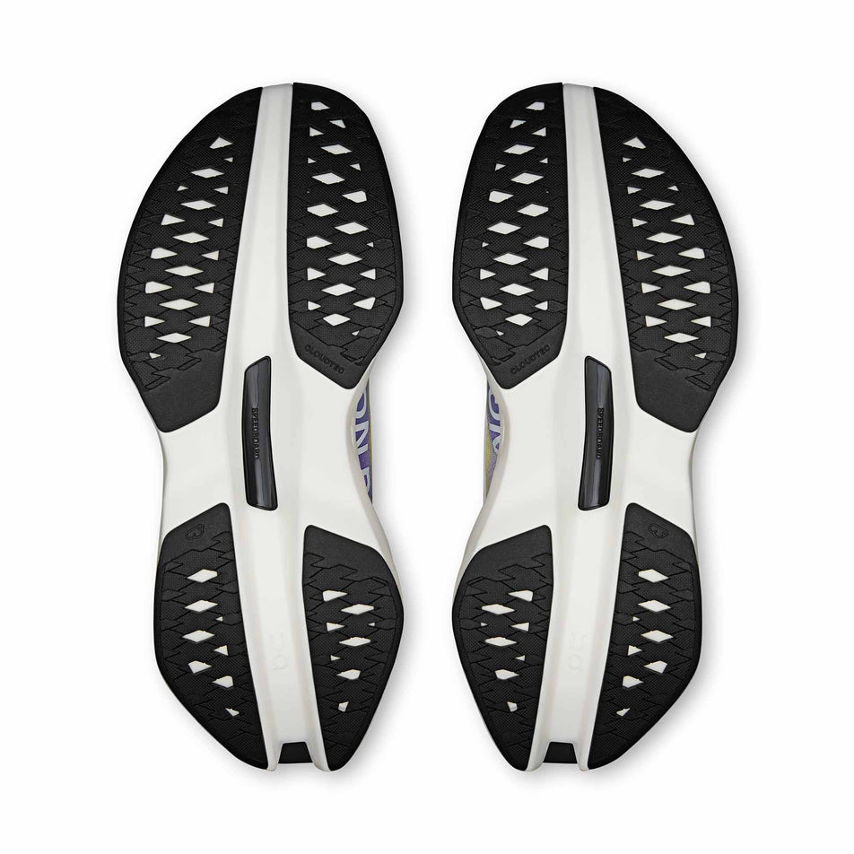 The outsoles of a pair of On Women's Cloudboom Max Running Shoes in the White/Juniper colourway.