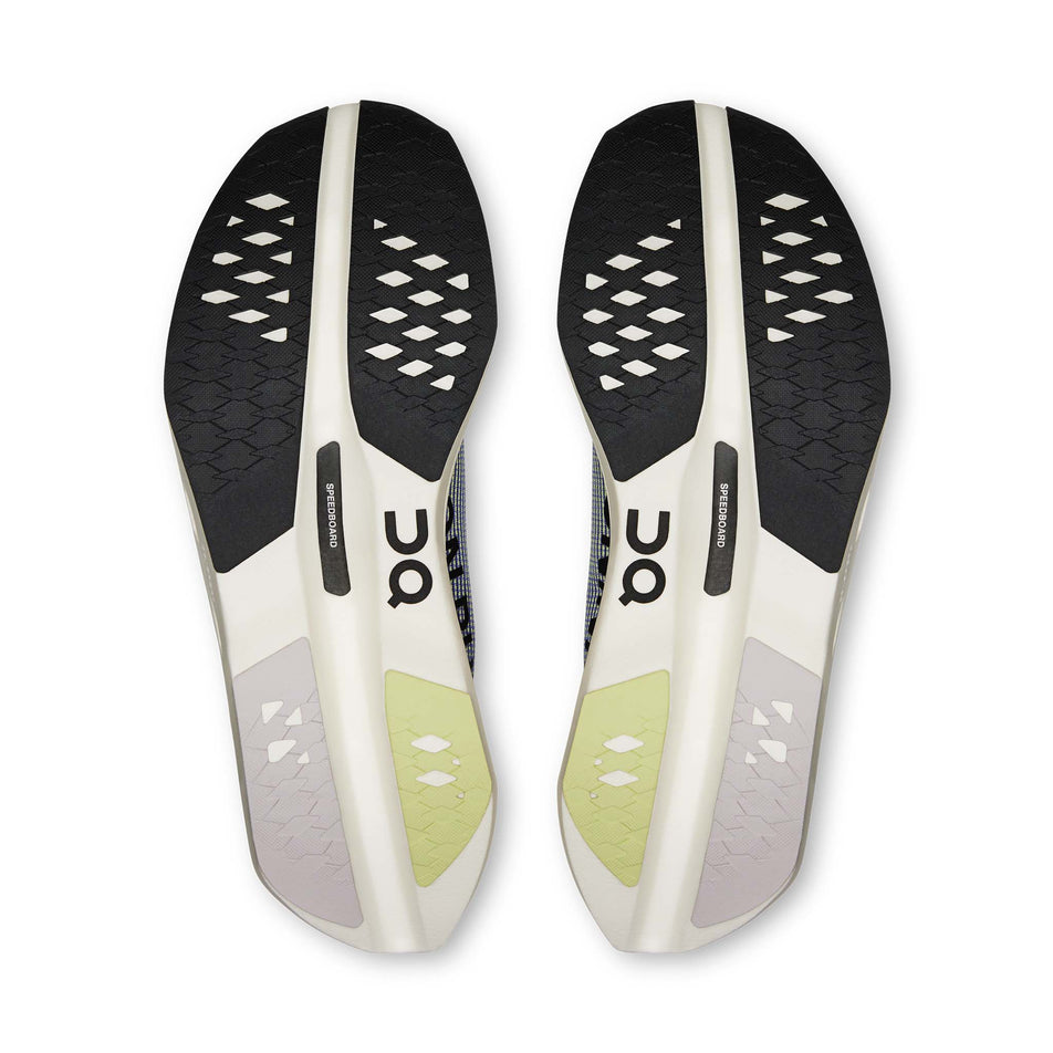 The outsoles of a pair of On Women's Cloudboom Volt Running Shoes in the Juniper/Limelight colourway.