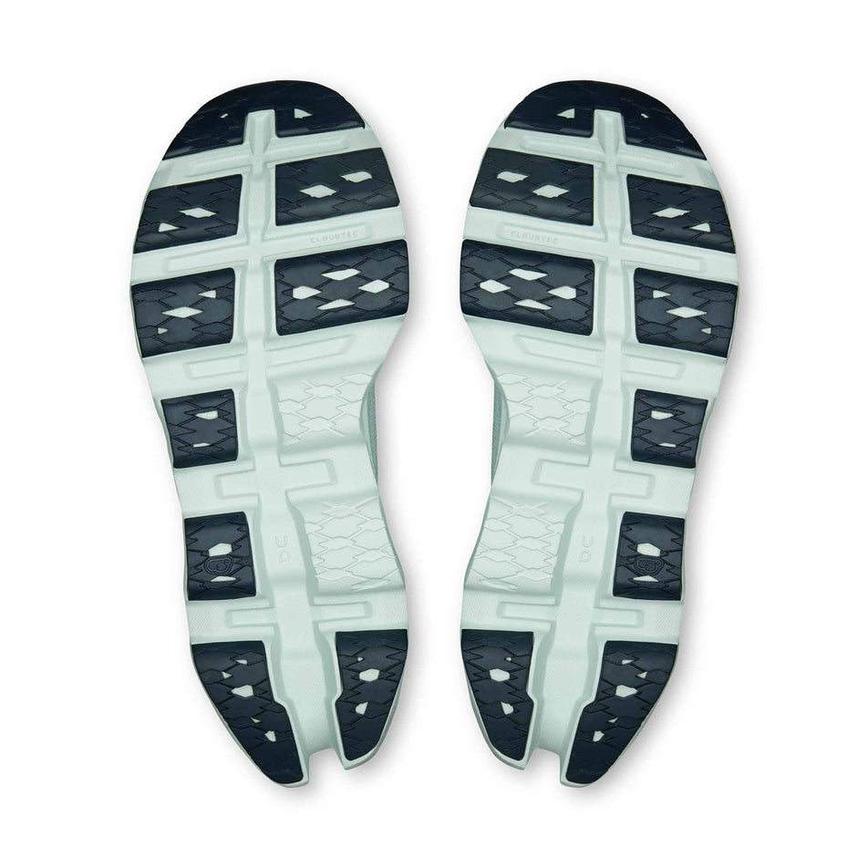 The outsoles of a pair of On Women's Cloudmonster 3 Running Shoes in the Brook/Flurry colourway.