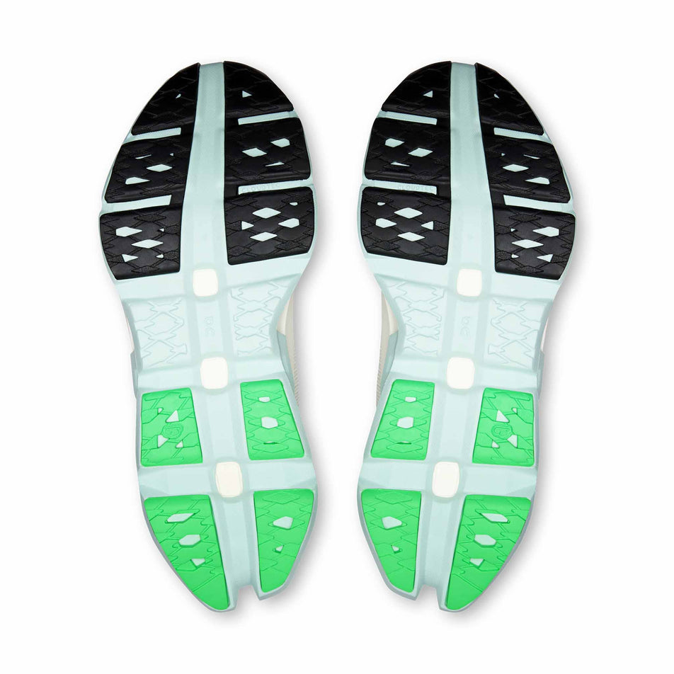 The outsoles of a pair of On Women's Cloudmonster 3 Hyper Running Shoes in the Ivory/Flurry colourway.