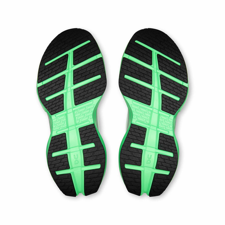 The outsoles of a pair of On Women's Cloudrunner Max Running Shoes in the White/Verdite colourway.