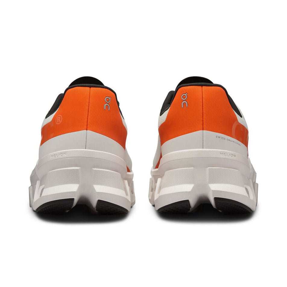 The back of a pair of On Men's Cloudmonster Running Shoes in the Undyed-White/Flame colurway (8002663415970)