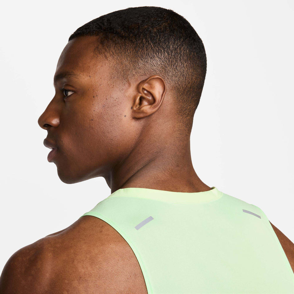 Close-up back view of a model wearing a Nike Men's Rise 365 Dri-FIT Running Tank in the Vapor Green/Reflective Silv colourway. Only the upper section of the top is visible in the image. (8215870767266)