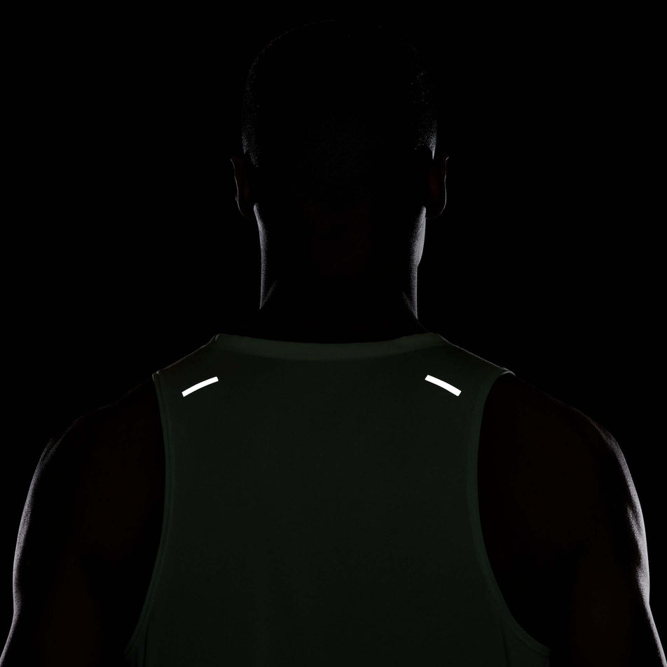 The reflective details which are on the top part of a Nike Men's Rise 365 Dri-FIT Running Tank in the Vapor Green/Reflective Silv colourway. The top is being worn by a model. (8215870767266)