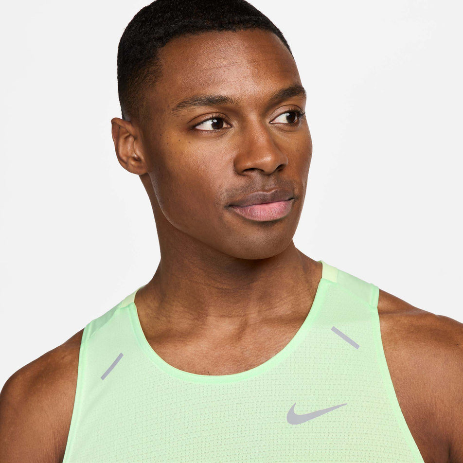 Close-up front view of a model wearing a Nike Men's Rise 365 Dri-FIT Running Tank in the Vapor Green/Reflective Silv colourway. Only the upper section of the top is visible in the image. (8215870767266)
