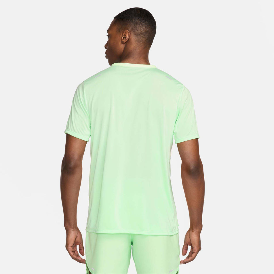 Back view of a model wearing a Nike Men's Rise 365 Dri-FIT Short-Sleeve Running Top in the Vapor Green/Reflective Silv colourway. Model is also wearing Nike running shorts. (8215872766114)