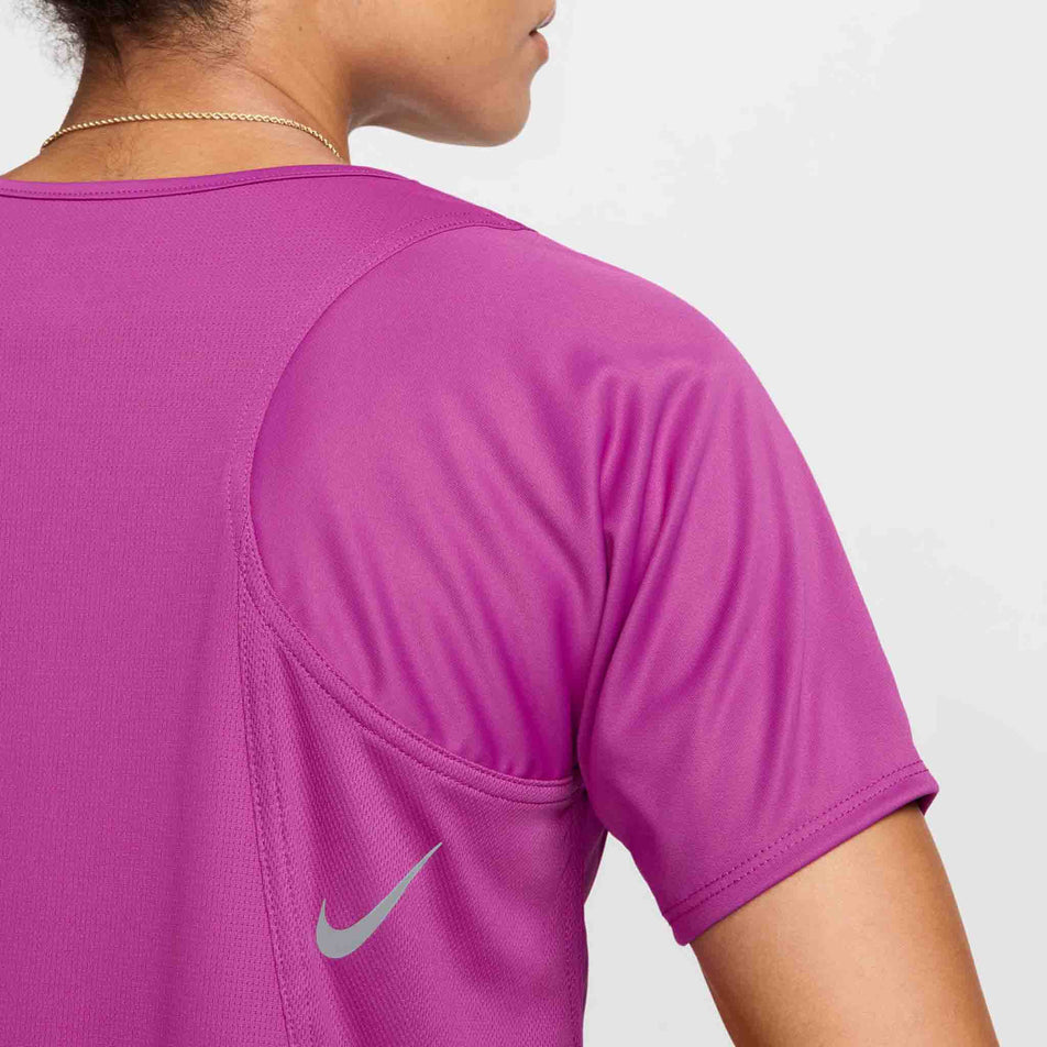 Close-up back view of a model wearing a Nike Women's Dri-FIT Race Short-Sleeve Running Top in the Hot Fuchsia/Reflective Silv colourway. (8399187640482)