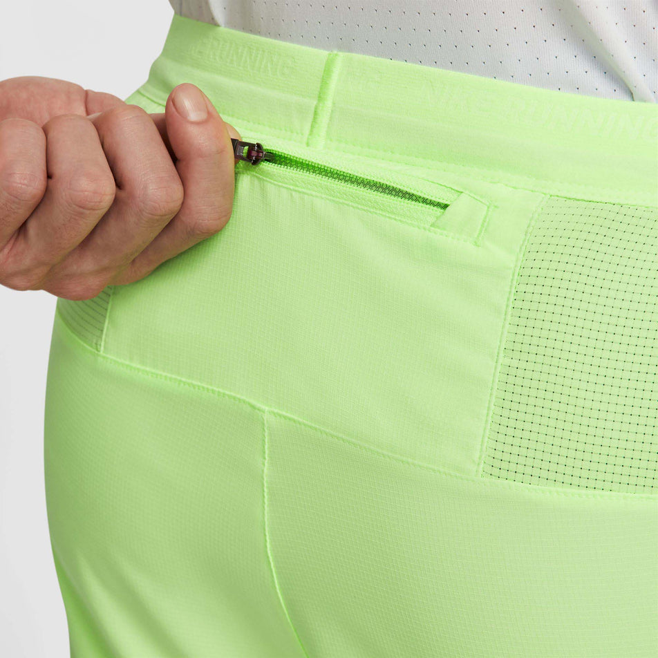 A model highlighting the zipped back pocket on a pair of Nike Men's Stride Dri-FIT 5
