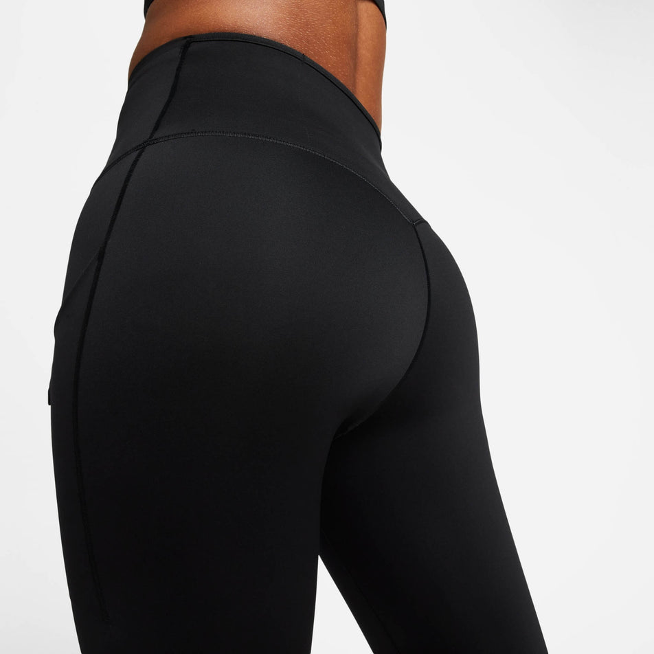 Close-up back view of the upper third of a pair of Nike Women's Go Firm-Support High-Waisted Full-Length Leggings with Pockets in the Black/Black colourway. Leggings are being worn by a model. (8140163252386)