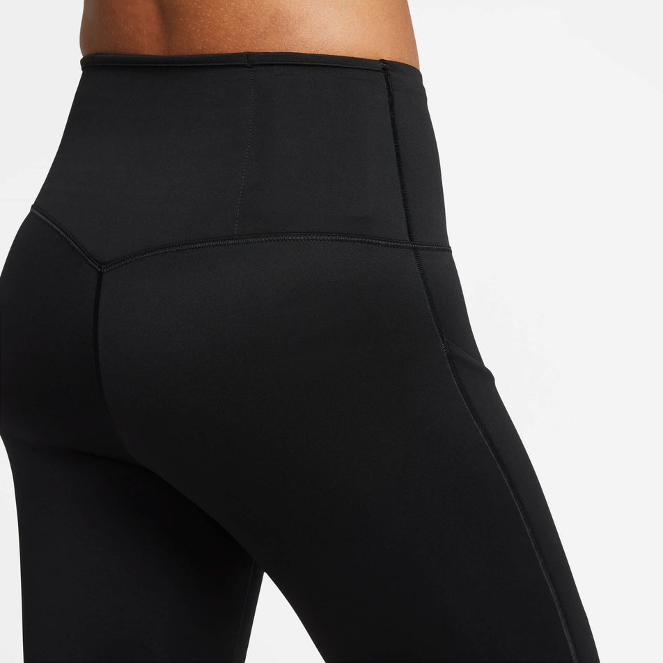 Close-up back view of the upper third of a pair of Nike Women's Go Firm-Support High-Waisted Full-Length Leggings with Pockets in the Black/Black colourway. Leggings are being worn by a model. (8140163252386)