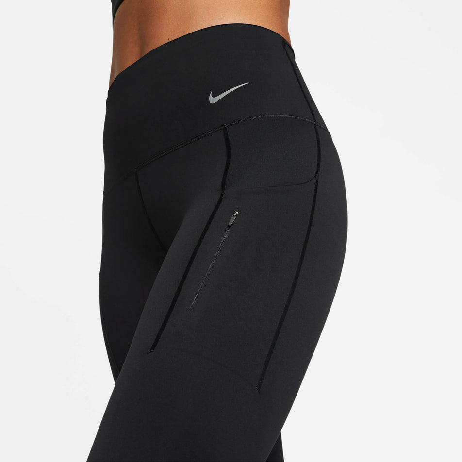 Close-up front view of the upper half of a pair of Nike  Women's Go Firm-Support High-Waisted Full-Length Leggings with Pockets in the Black/Black colourway. Leggings are being worn by a model. (8140163252386)